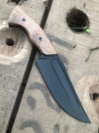Black blade hunting knife on wood background
