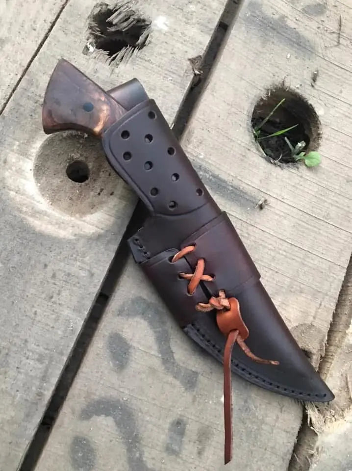 Black powder coat hunting knife on wood background