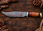 Brass pommel and leather handle detail on copper Damascus Bowie knife
