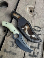 Black powder coat recurve blade with fuller and serrated section close-up