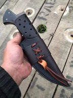 D2 steel hunting knife on wood background