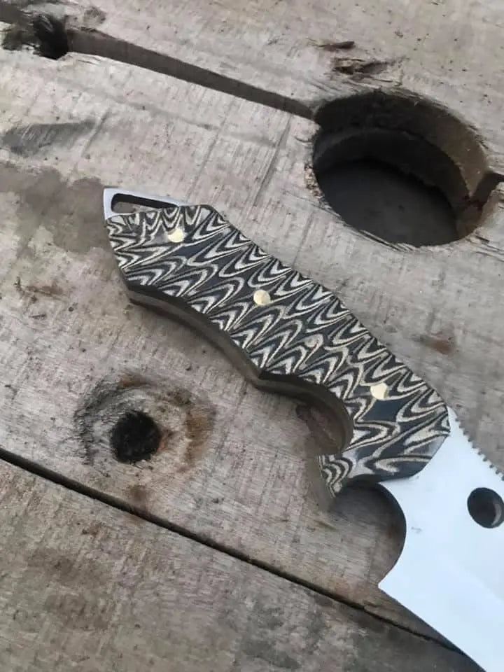 Black and white micarta handle with brass pins detail