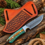 Damascus steel drop point blade close-up on cowboy knife with turquoise handle