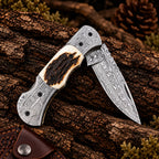 Damascus folding knife open on wood background