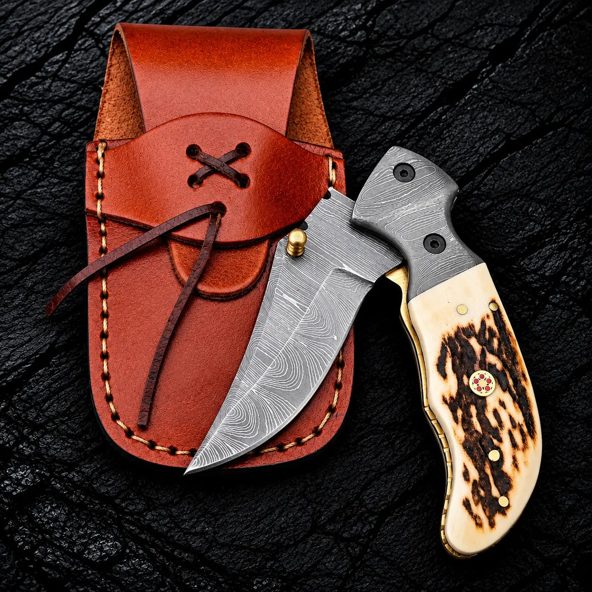 Damascus steel clip point blade with brass thumb stud close-up