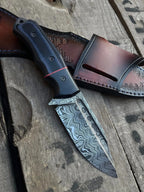 Damascus steel blade with fuller close-up on full tang skinner knife