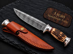 Stag antler handle with silver guard and pommel detail on Damascus knife