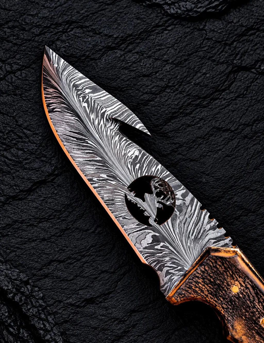 Feather Damascus blade pattern with wire-cut deer head design close-up