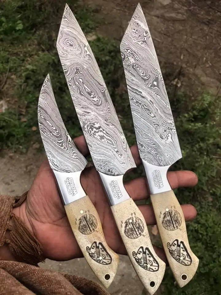 Damascus steel 3-piece knife set on wood background