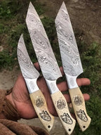 Damascus steel 3-piece knife set on wood background