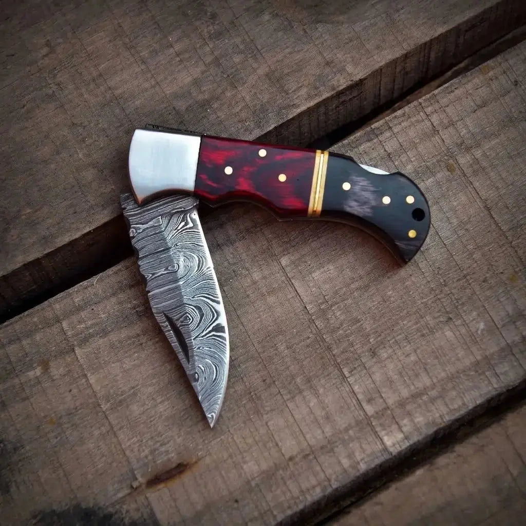 Damascus steel folding pocket knife blade close-up with leather sheath
