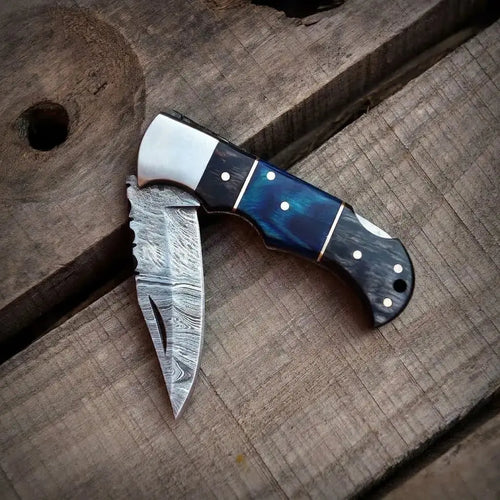 Handmade Damascus steel folding pocket knife with blue wood handle and leather sheath