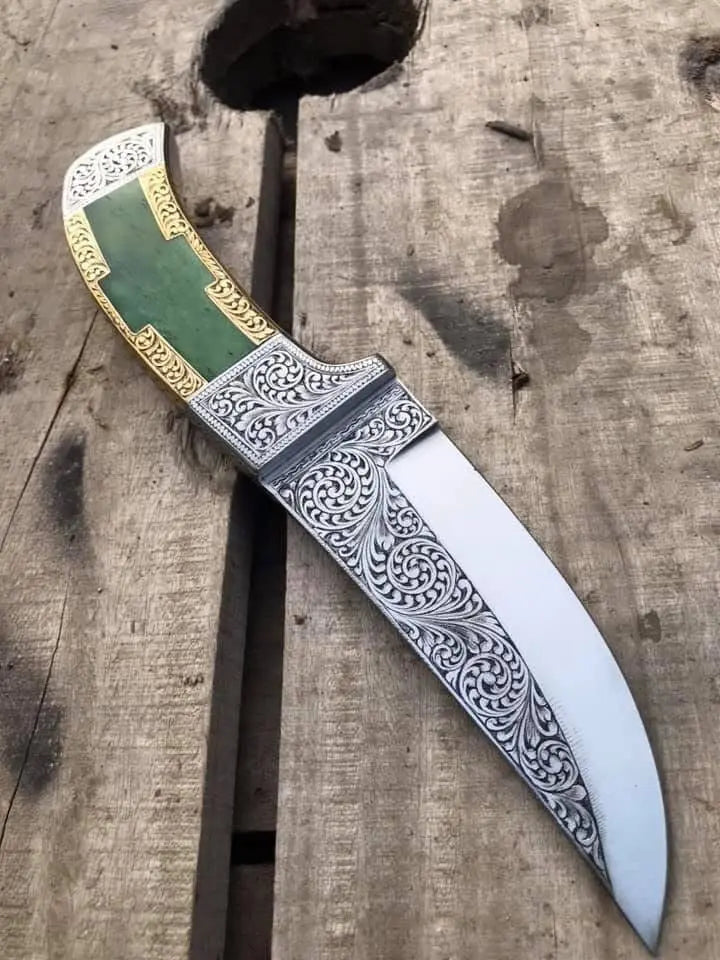 Green stone and gold brass handle detail on engraved dagger