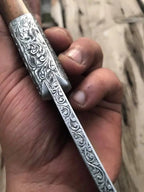Hand engraved skinner knife on wood background - full length view