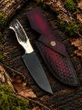 Handmade black powder coated D2 steel skinner knife with stag horn handle, brass bolsters and burgundy basket weave Italian leather sheath